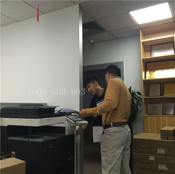 蔡師傅在和陳先生說柯尼卡美能達C360機器激光器大概在哪個位置-科頤辦公